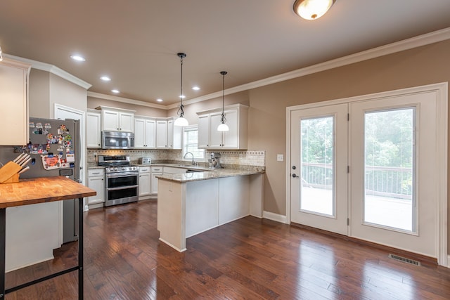 kitchen featuring kitchen peninsula, plenty of natural light, stainless steel appliances, and white cabinets