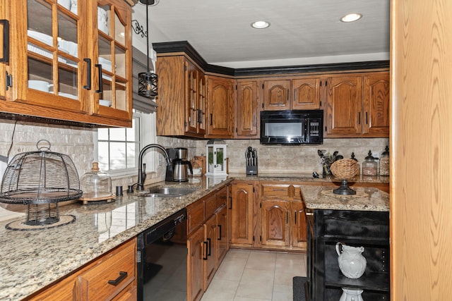 kitchen featuring light tile patterned floors, sink, backsplash, black appliances, and light stone countertops