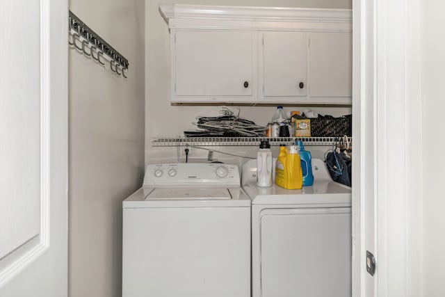 clothes washing area with washer and dryer and cabinets