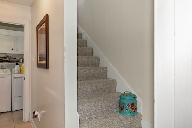 stairway with washing machine and dryer and tile patterned floors