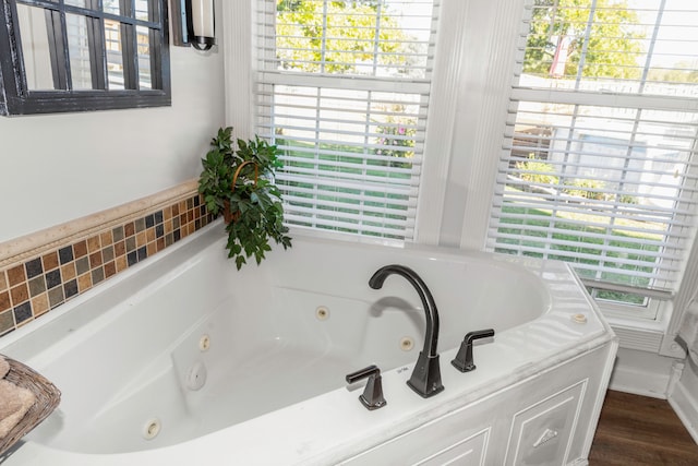 bathroom featuring hardwood / wood-style floors, a healthy amount of sunlight, and a tub