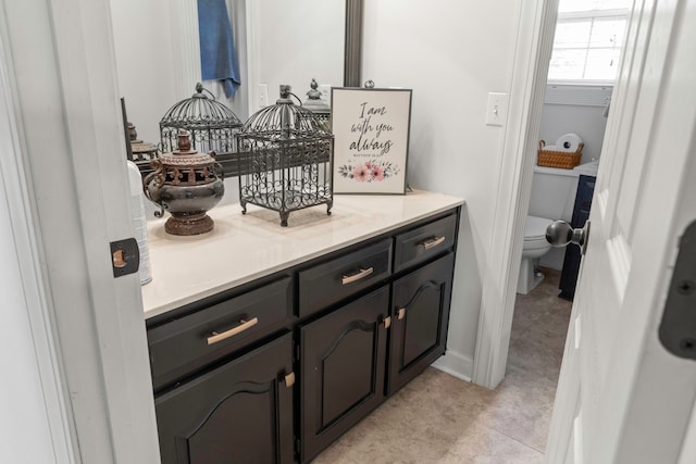 bathroom with tile patterned flooring, vanity, and toilet