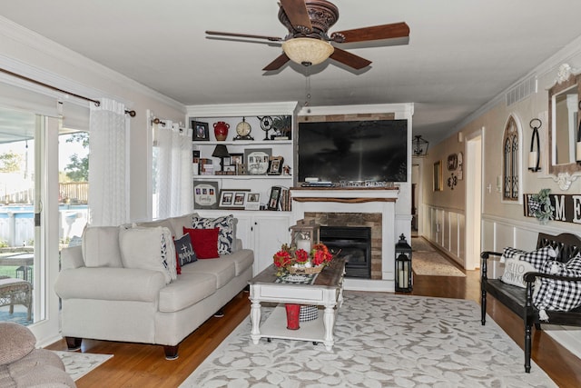 living room with ceiling fan, hardwood / wood-style flooring, and ornamental molding