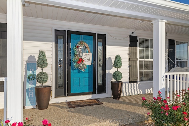 view of exterior entry featuring covered porch