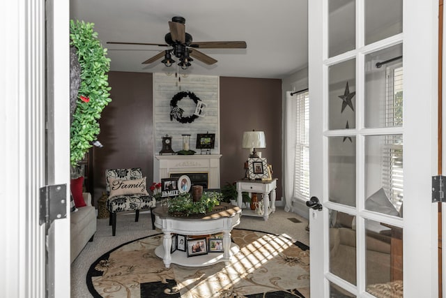 living area with carpet and ceiling fan