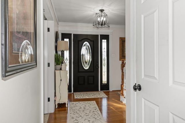 foyer featuring a chandelier, ornamental molding, and dark hardwood / wood-style floors