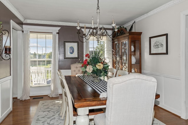 dining area with ornamental molding, dark hardwood / wood-style flooring, and a notable chandelier