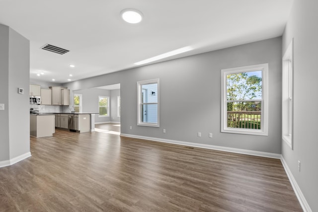 unfurnished living room with recessed lighting, visible vents, dark wood finished floors, and baseboards