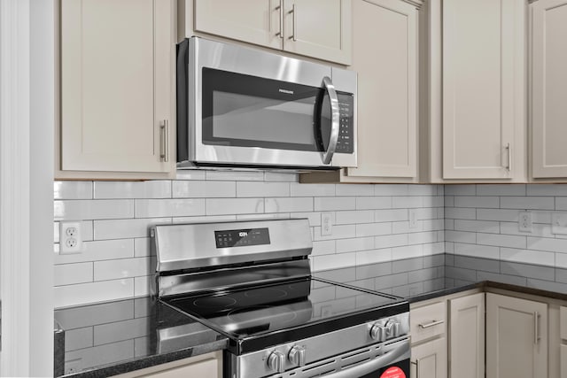 kitchen with appliances with stainless steel finishes, decorative backsplash, and dark stone counters