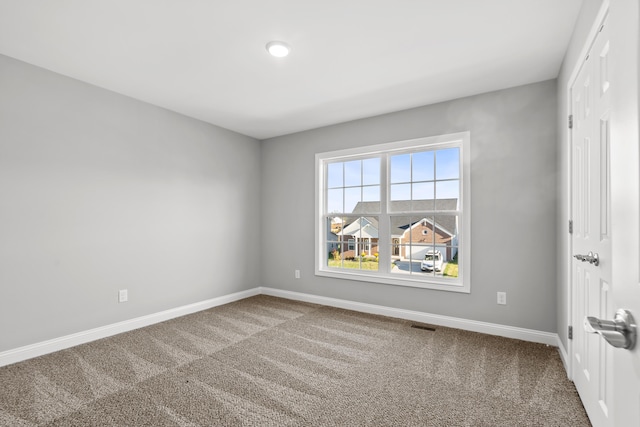 unfurnished room with visible vents, baseboards, and carpet flooring