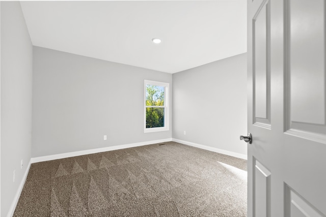 carpeted spare room featuring baseboards