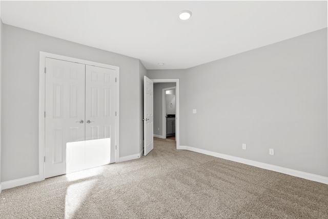 unfurnished bedroom featuring carpet floors, a closet, and baseboards