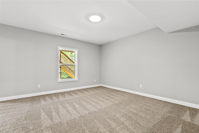 carpeted empty room with visible vents and baseboards