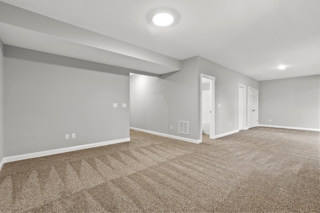 finished below grade area featuring carpet, visible vents, and baseboards