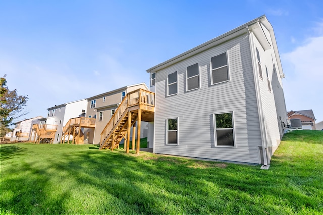 rear view of house featuring a wooden deck, stairs, and a yard