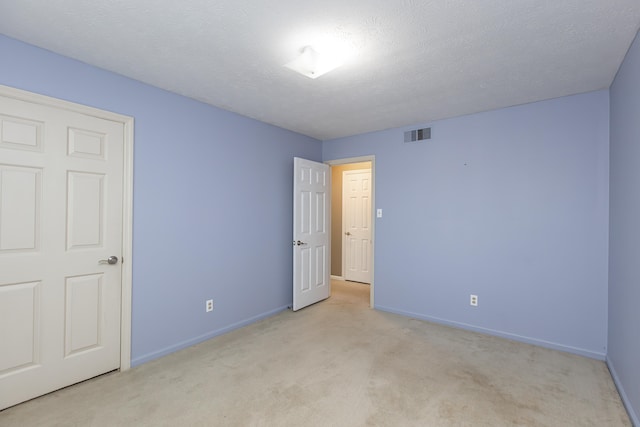 carpeted spare room featuring a textured ceiling