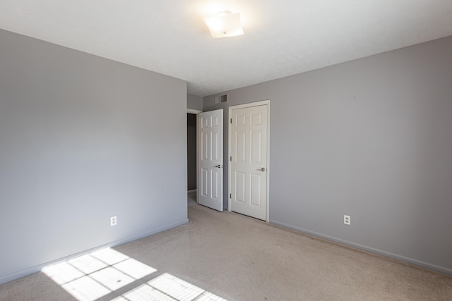 spare room featuring light carpet