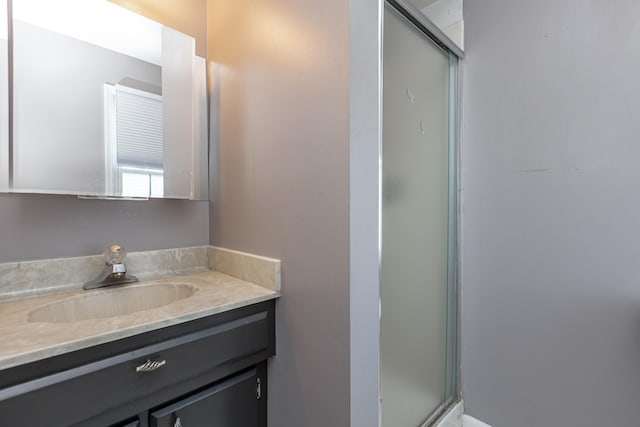 bathroom with vanity and a shower with shower door