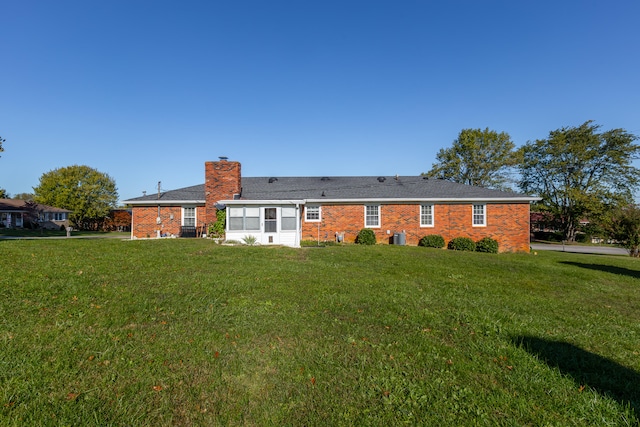 rear view of house featuring a yard