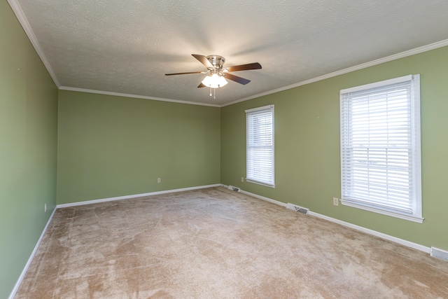 carpeted spare room featuring ornamental molding, a textured ceiling, and ceiling fan