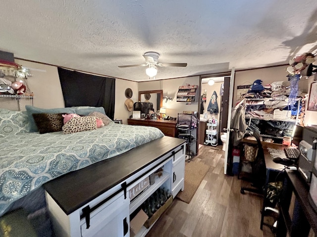 bedroom with hardwood / wood-style floors, a textured ceiling, and ceiling fan