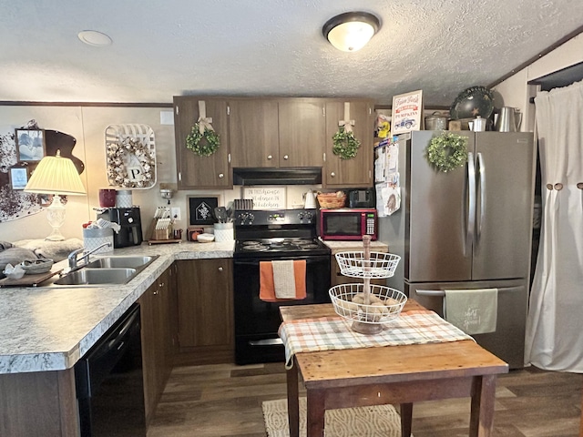 kitchen featuring black appliances, dark brown cabinetry, dark hardwood / wood-style floors, sink, and a textured ceiling