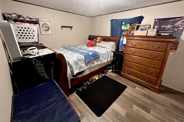 bedroom featuring light hardwood / wood-style floors and a textured ceiling