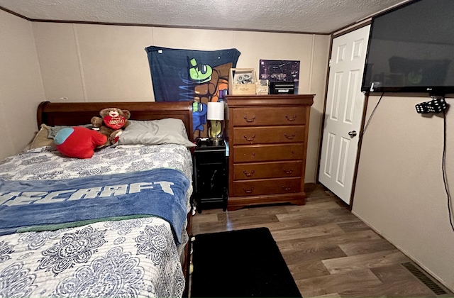 bedroom with hardwood / wood-style flooring and a textured ceiling