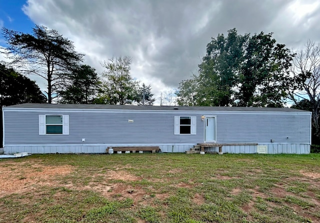 rear view of house featuring a yard