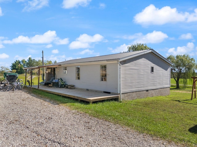 rear view of property featuring a yard and a wooden deck