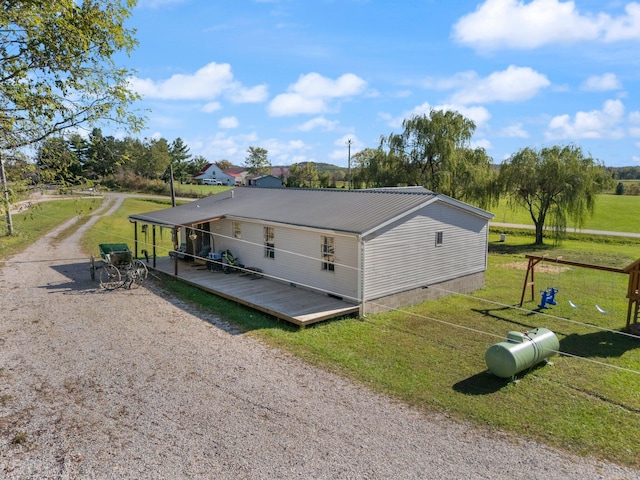 view of home's exterior with a deck and a lawn