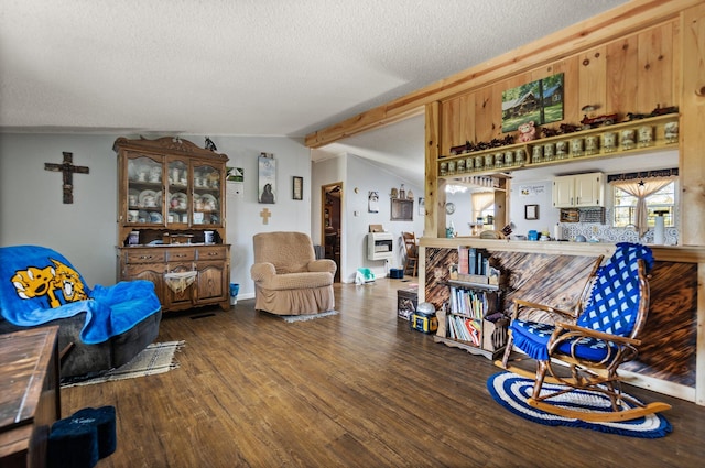 living room featuring lofted ceiling with beams, hardwood / wood-style floors, and a textured ceiling