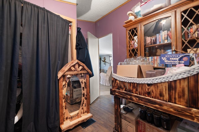 interior space with ornamental molding, dark hardwood / wood-style flooring, and a textured ceiling