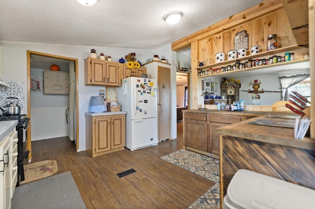 kitchen with vaulted ceiling, white refrigerator, dark hardwood / wood-style flooring, and a textured ceiling