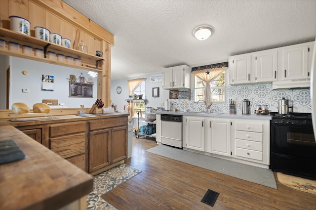 kitchen featuring white dishwasher, white cabinetry, and black electric range