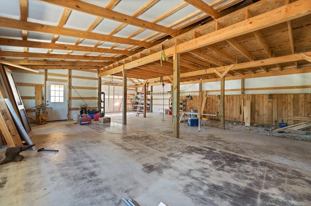 miscellaneous room featuring wood walls and concrete floors