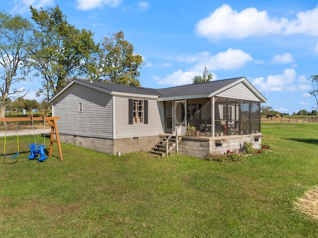 rear view of house with a sunroom and a lawn