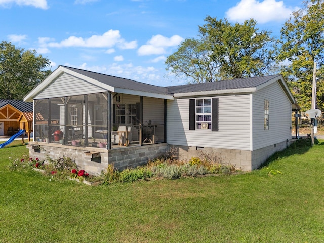 rear view of house featuring a sunroom and a yard