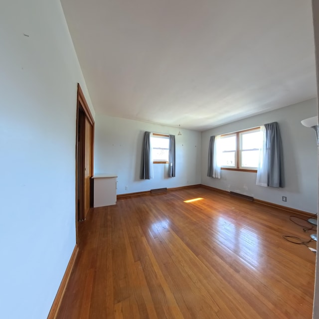 unfurnished room featuring baseboards and wood finished floors