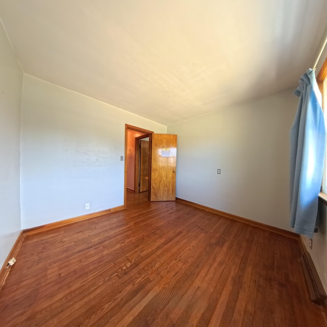 empty room featuring baseboards and wood finished floors