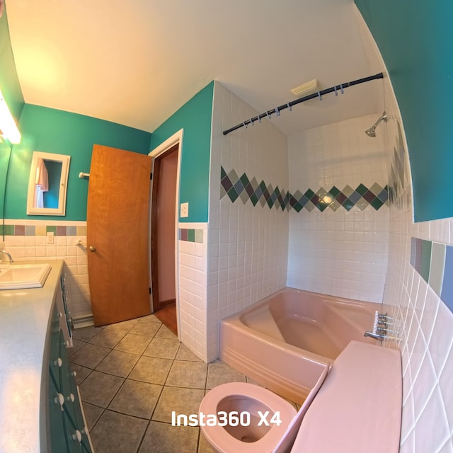 full bathroom featuring bathing tub / shower combination, vanity, tile walls, wainscoting, and tile patterned floors