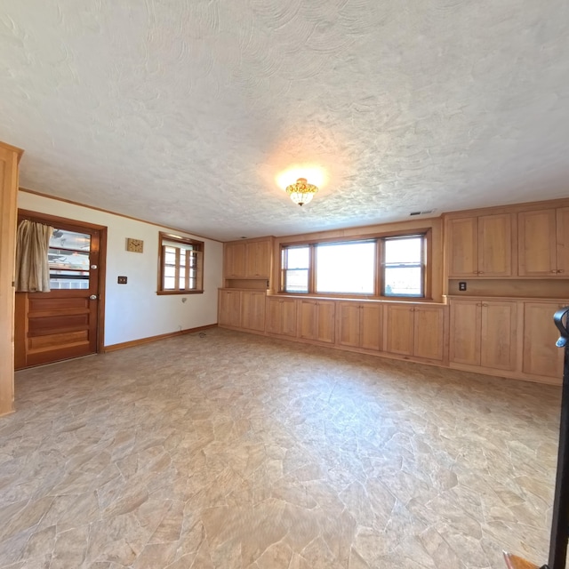 empty room with a textured ceiling and baseboards