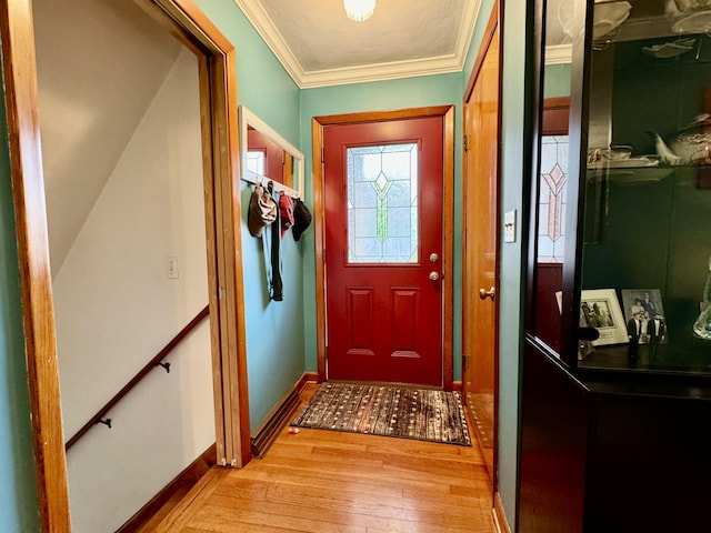 doorway to outside featuring ornamental molding, light wood-style flooring, and baseboards