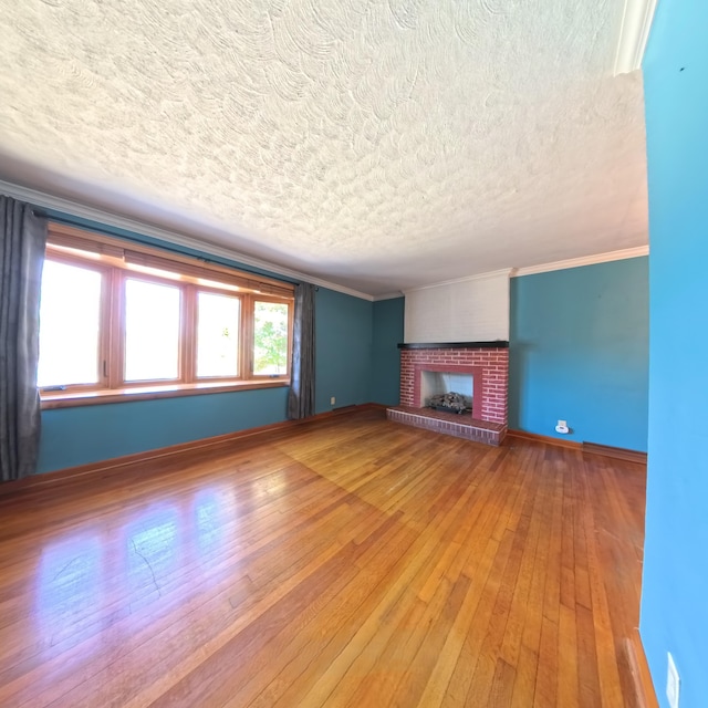 unfurnished living room with baseboards, a brick fireplace, wood finished floors, and crown molding