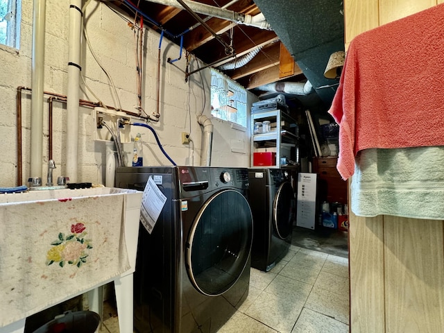 washroom featuring laundry area, a sink, and washing machine and clothes dryer