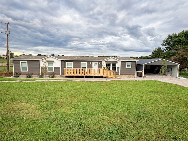 view of front facade with a carport, a front lawn, and a wooden deck