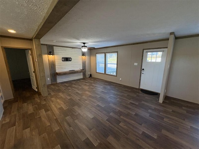 unfurnished living room with a textured ceiling, ceiling fan, dark hardwood / wood-style floors, and ornamental molding