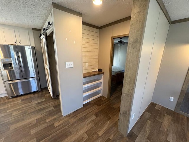 interior space featuring a textured ceiling, a barn door, and dark wood-type flooring