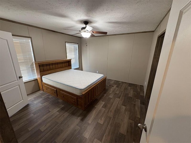 unfurnished bedroom with multiple windows, dark wood-type flooring, and a textured ceiling