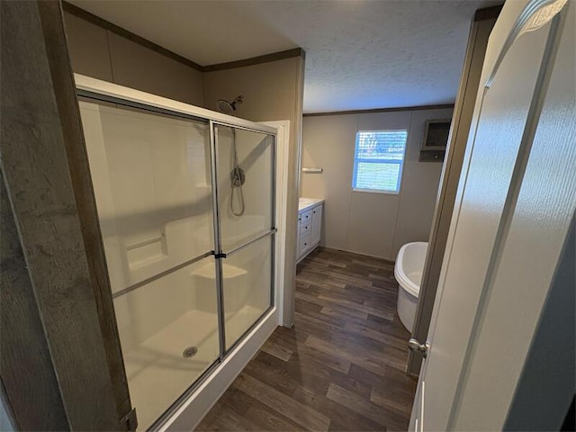 bathroom with a textured ceiling, vanity, hardwood / wood-style flooring, and walk in shower